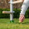 Woman securing the free standing universal chicken perch system to the land using the Omlet screw pegs