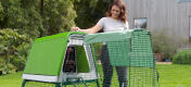 Woman opening the door to an Eglu Go up chicken coop