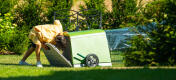 A child opening back door of the Eglu Go hutch attached to run.