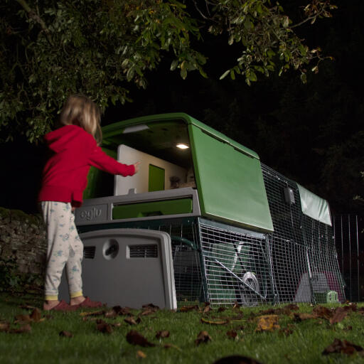 Girl with Omlet green Eglu Cube large chicken coop and run